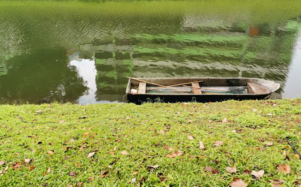 a small boat sitting on top of a lush green field