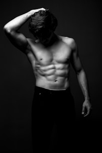 a shirtless man with his hands on his head