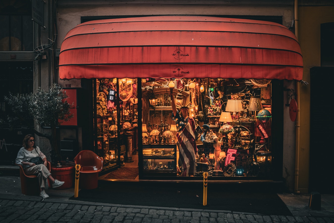 a woman sitting in a chair in front of a store