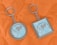 Two keychains lie on an orange quilted fabric background. One keychain is circular, while the other is square. Both have a metallic frame and feature a design with text that reads 'We are exporter of export quality bed sheets' surrounding an image of sheets.