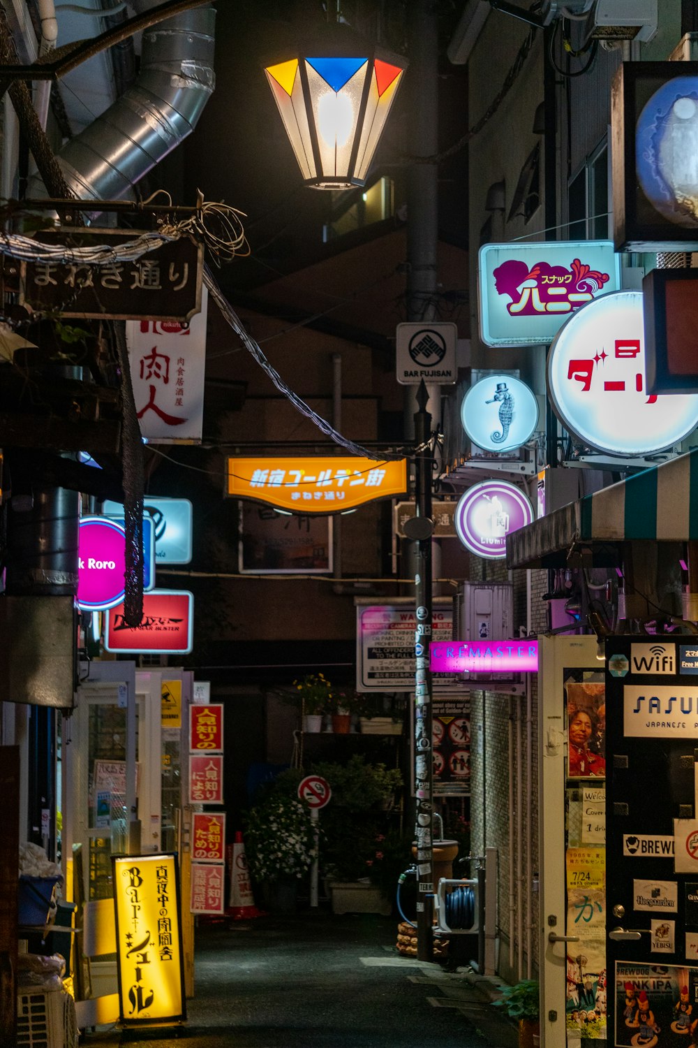 a narrow alley with many signs and lights