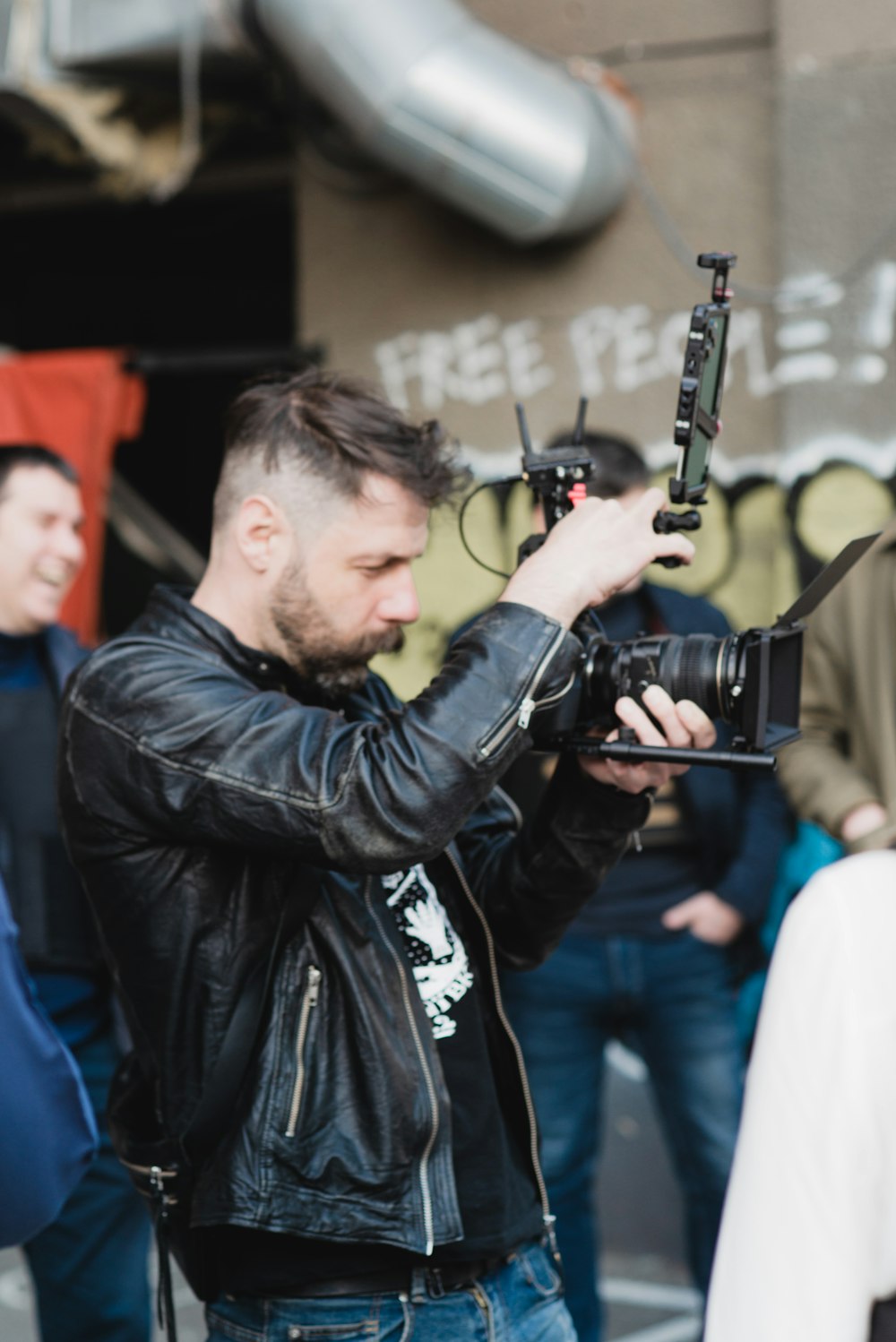 a man in a leather jacket holding a camera