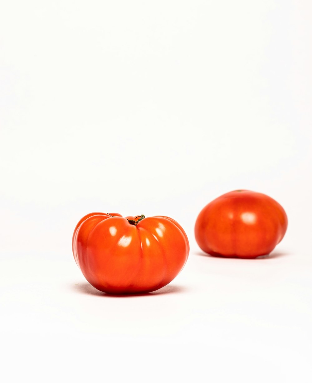 a couple of tomatoes sitting next to each other