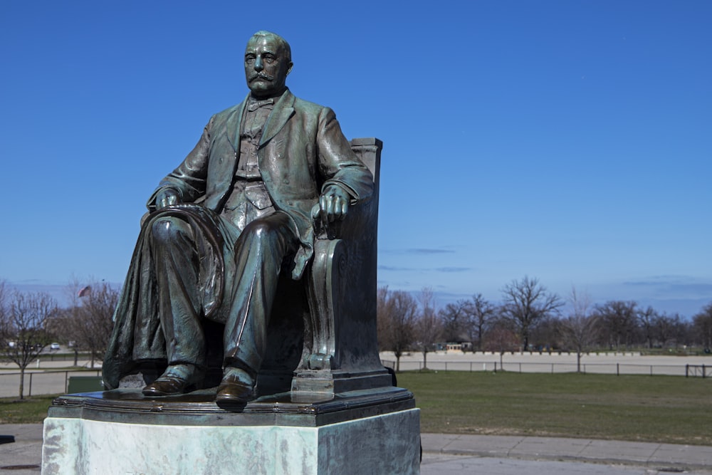 uma estátua de um homem sentado em uma cadeira