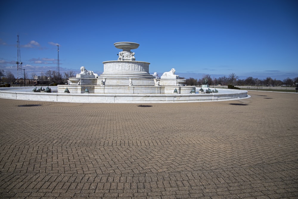a large white fountain sitting in the middle of a park