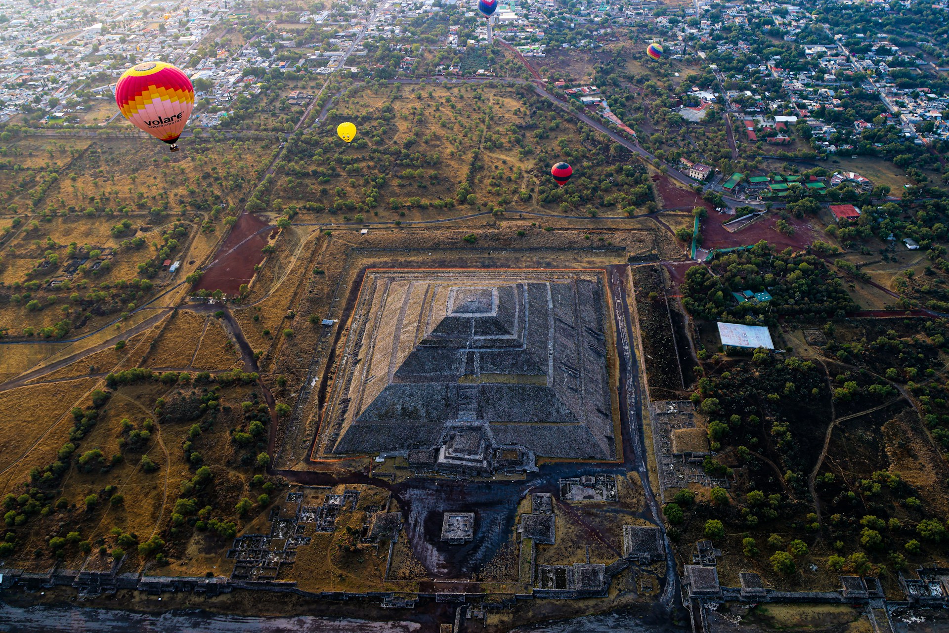 a hot air balloon flying over a city