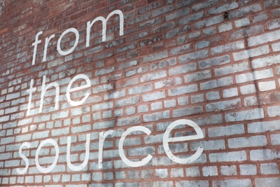 a brick wall with the words from the source painted on it