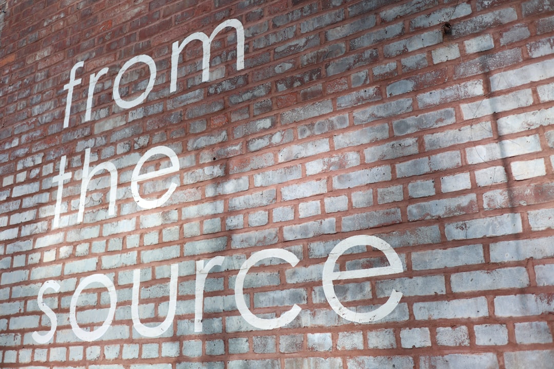 a brick wall with the words from the source painted on it, From the source