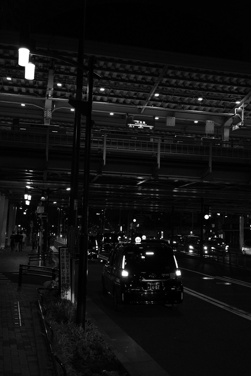 a black and white photo of a city street at night