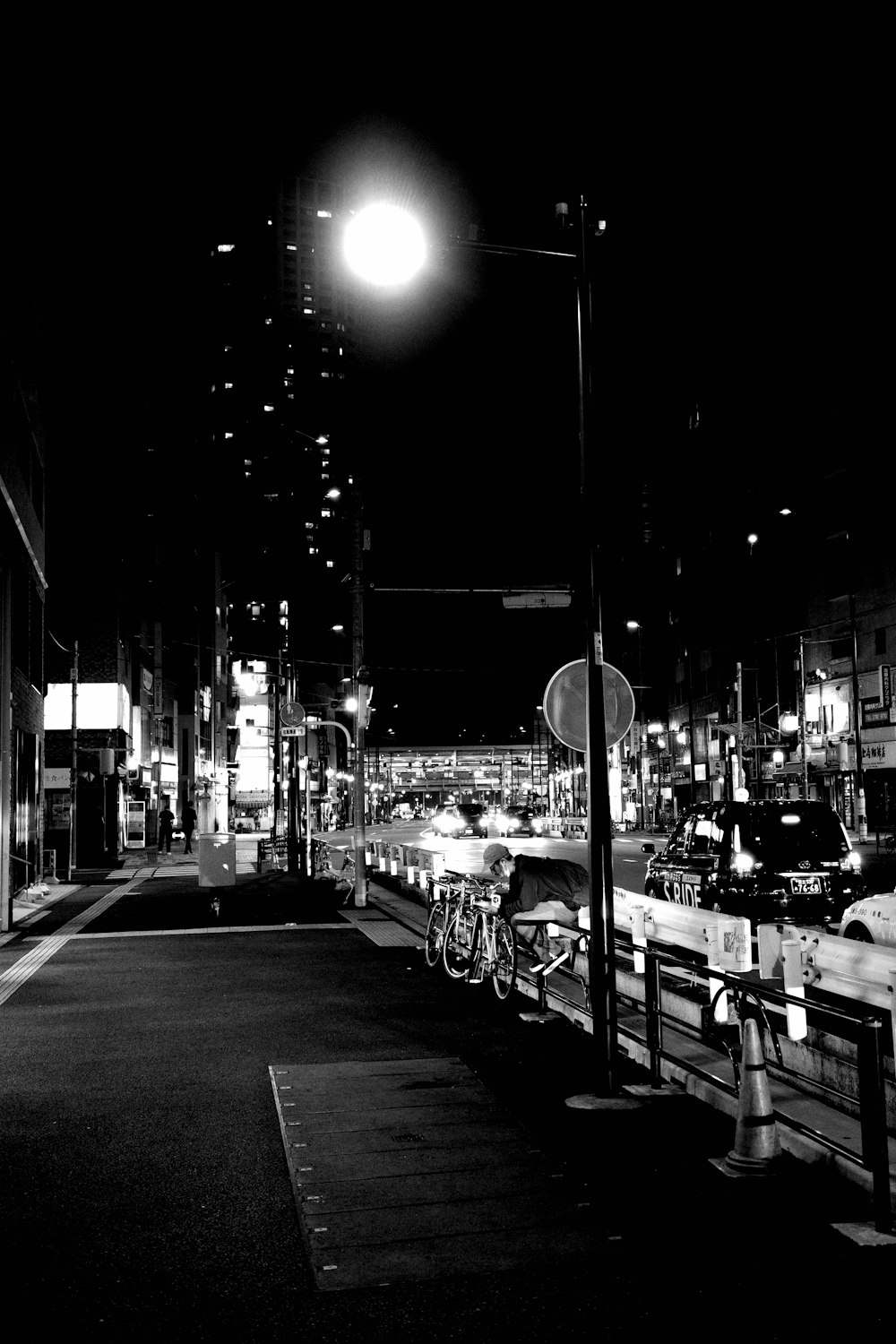 a black and white photo of a street at night