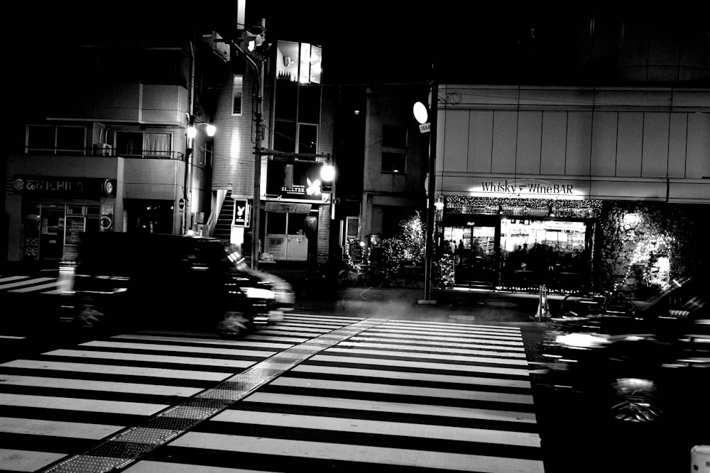 a black and white photo of a city street at night