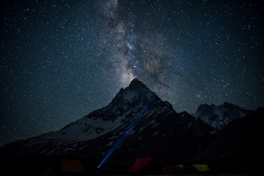 a night sky with stars above a mountain