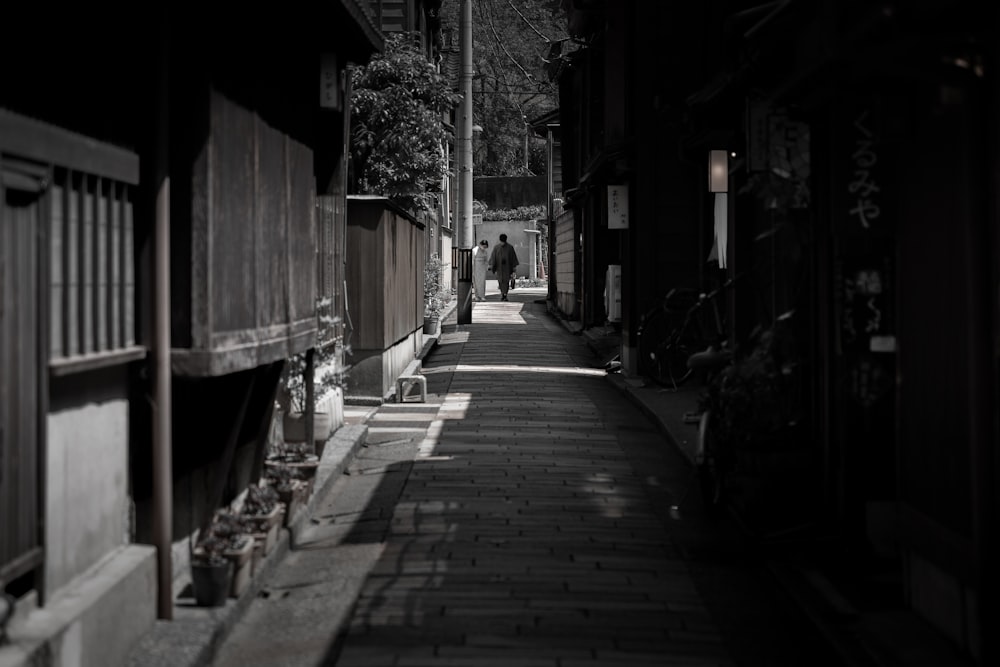 a man walking down a street next to tall buildings