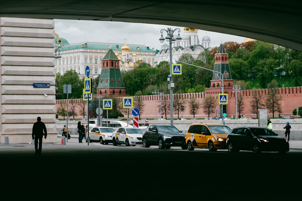 a city street filled with lots of traffic under a bridge