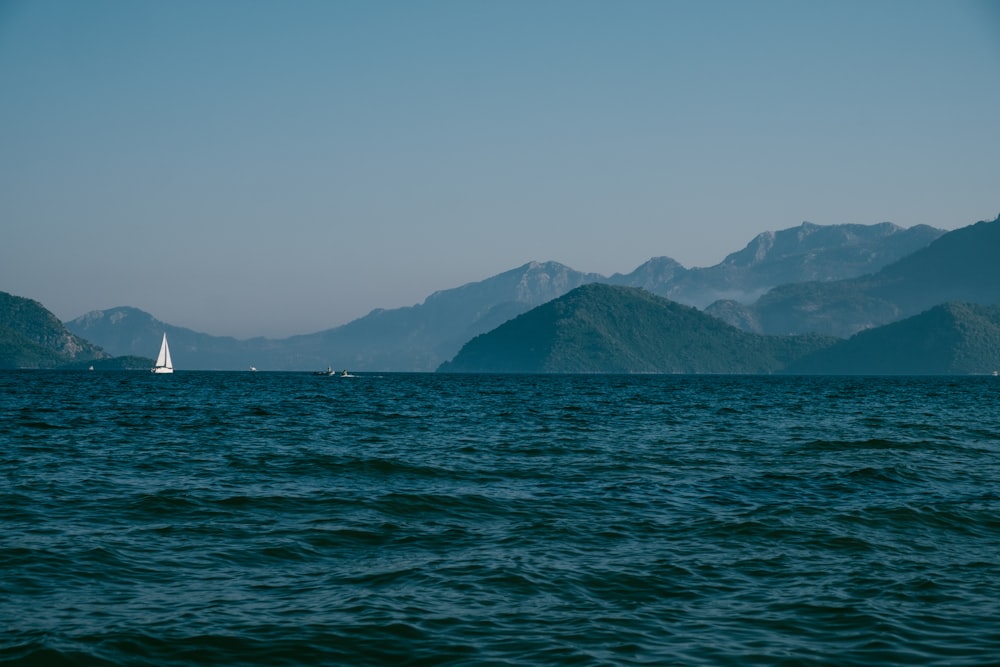 a large body of water with mountains in the background