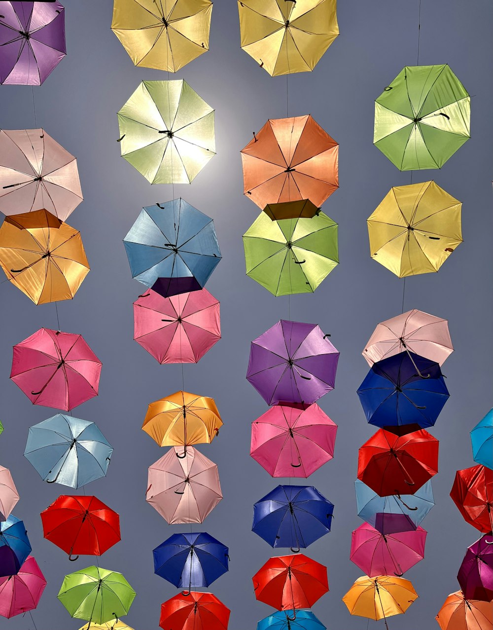 Ein Haufen bunter Regenschirme hängt in der Luft