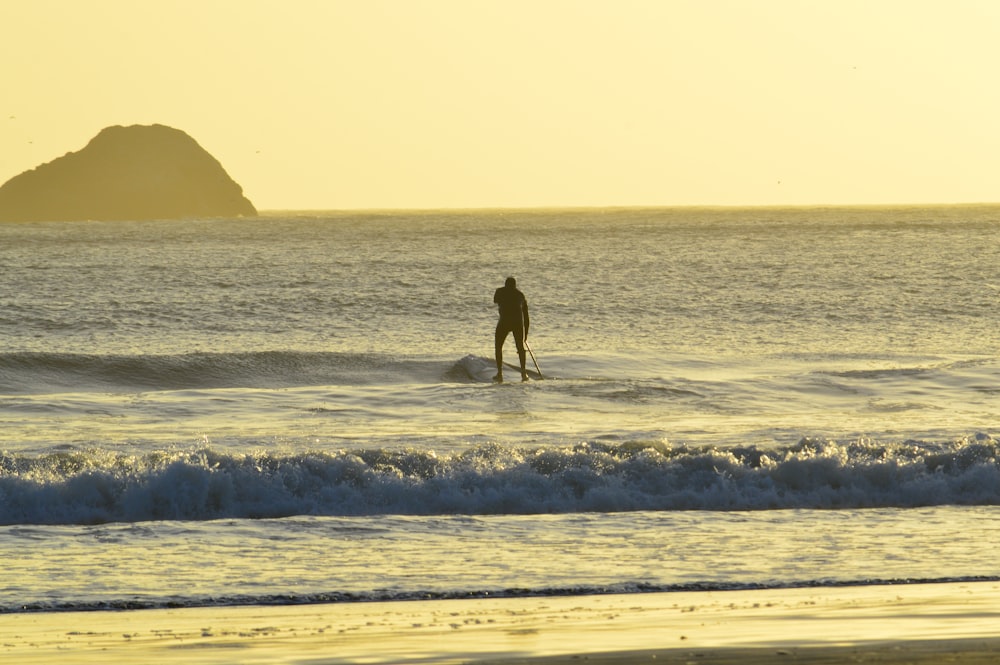 a person standing on a surfboard in the ocean