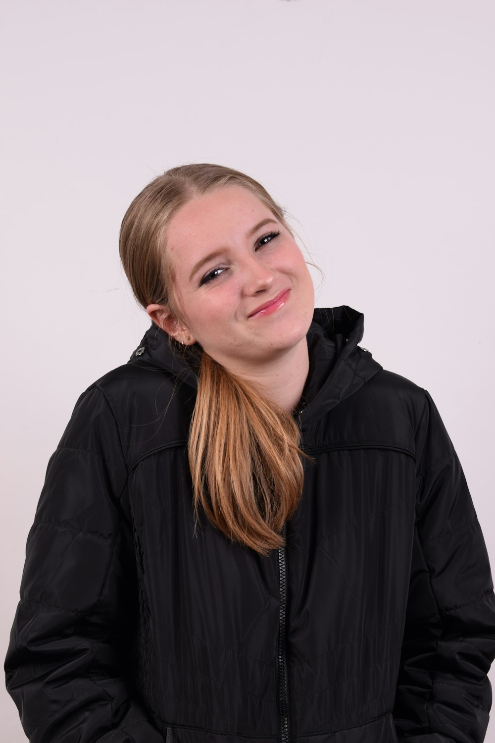 a girl in a black jacket posing for a picture