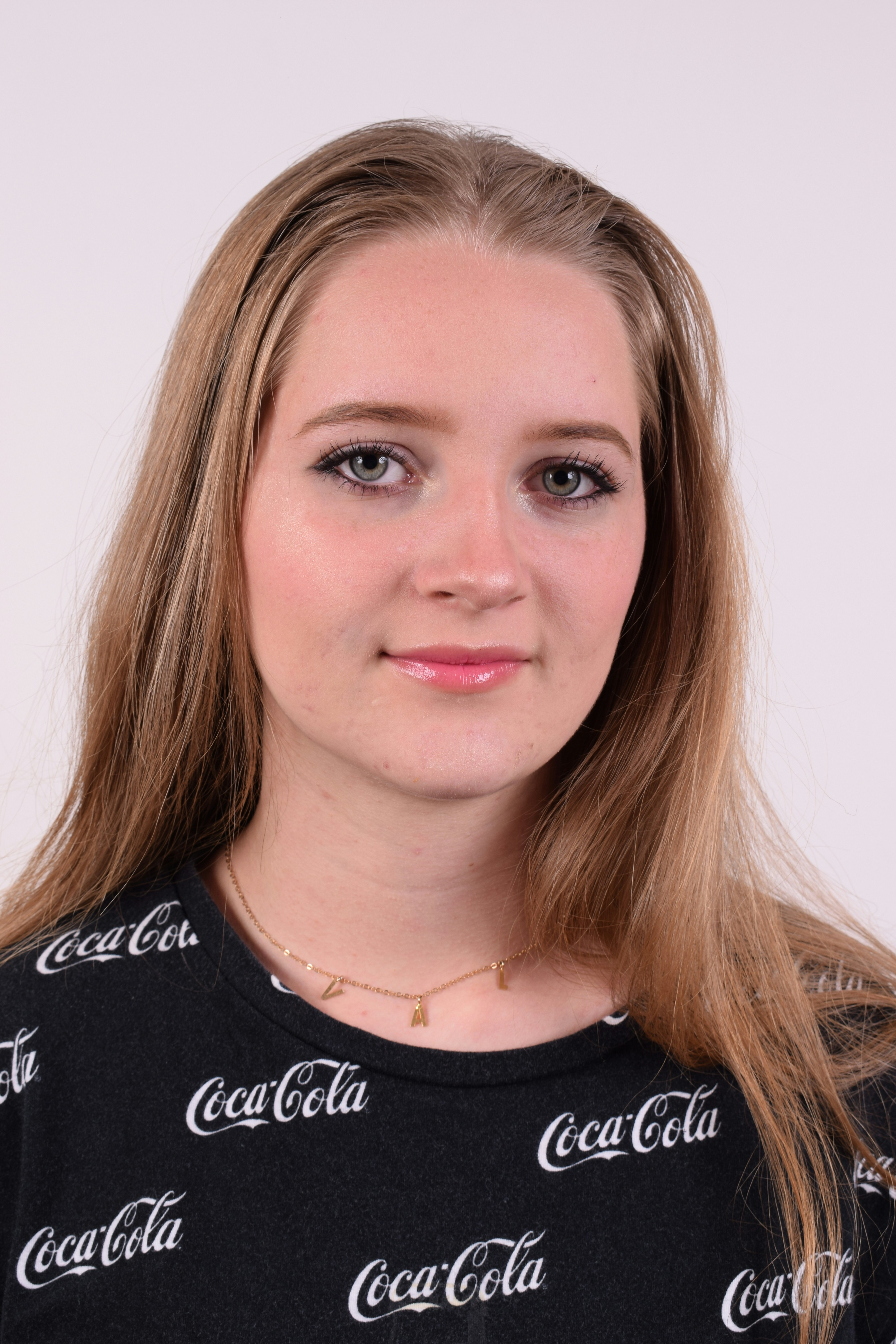 Une femme aux longs cheveux blonds portant une chemise Coca Cola