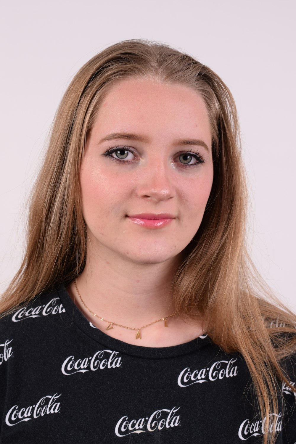 a woman with long blonde hair wearing a coca cola shirt