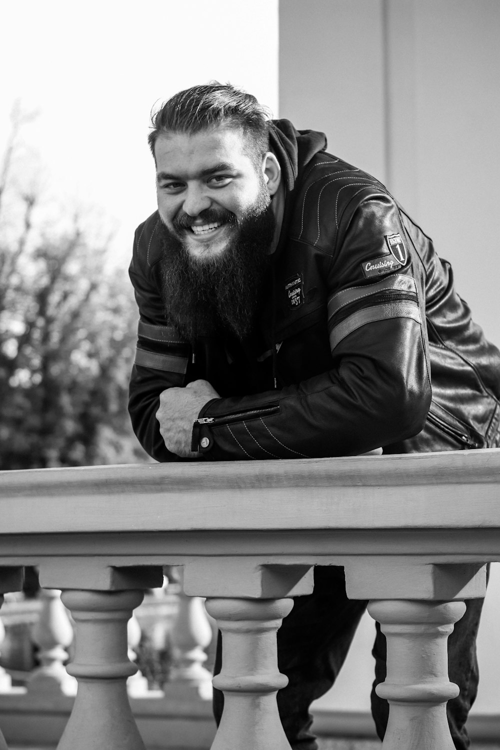 a man with a beard leaning on a railing