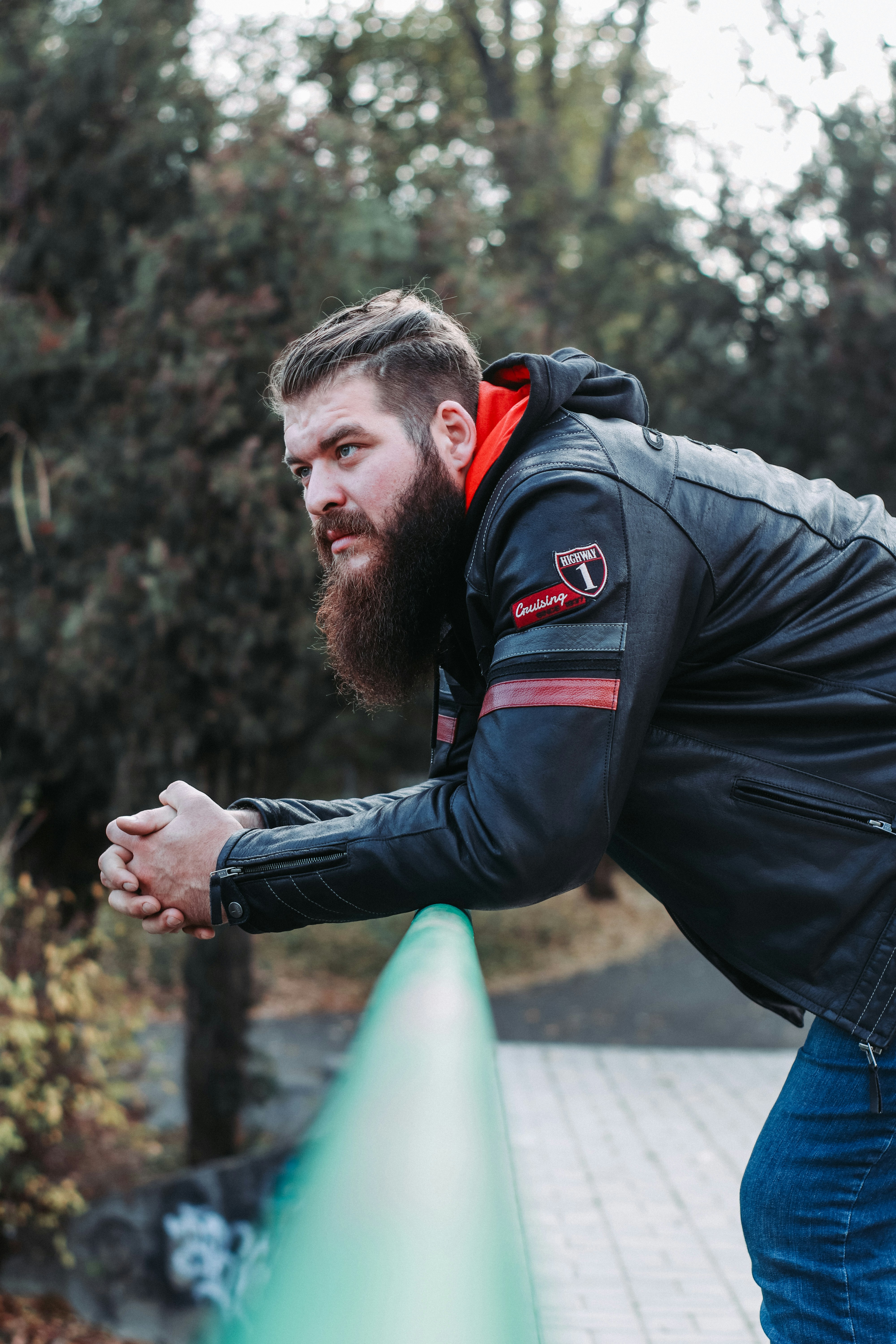 a man with a beard is leaning on a rail