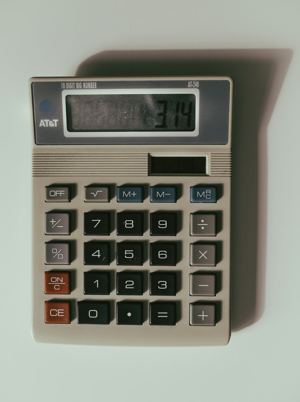 uma calculadora sentada em cima de uma mesa branca