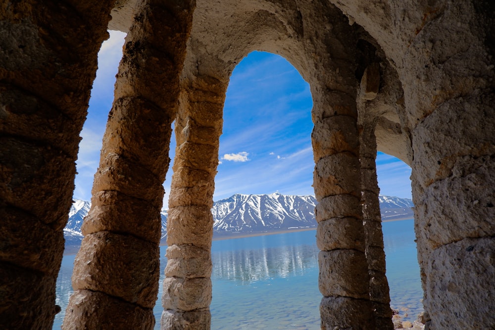 a view of a lake through some stone arches