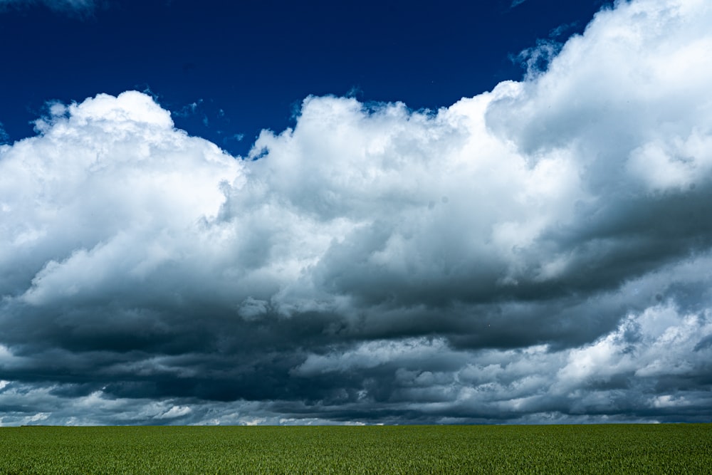 um campo verde sob um céu azul nublado