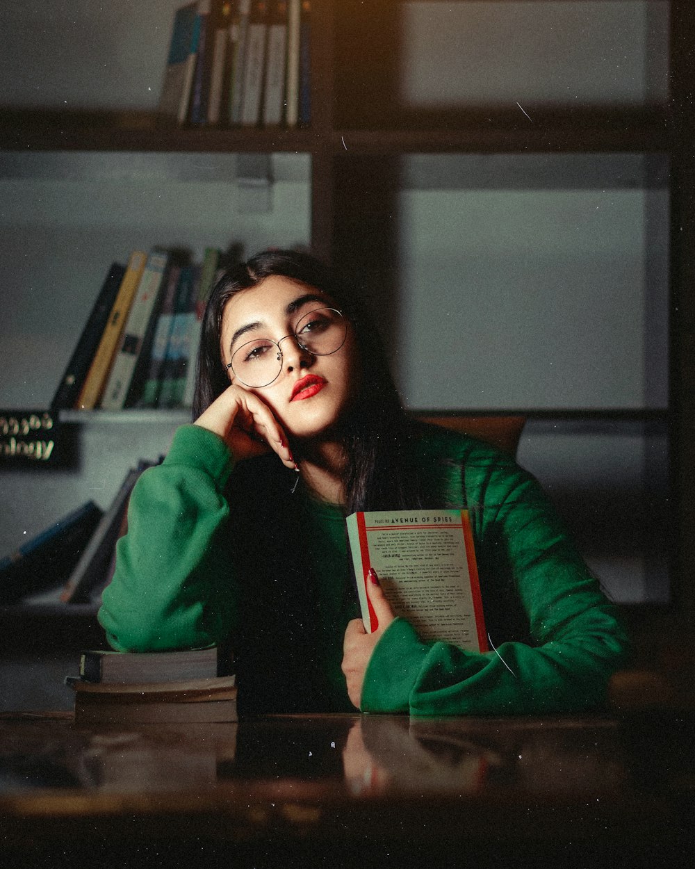 a woman sitting at a desk with a book in front of her