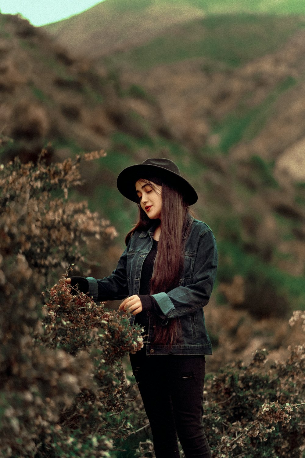 a woman with long hair wearing a black hat