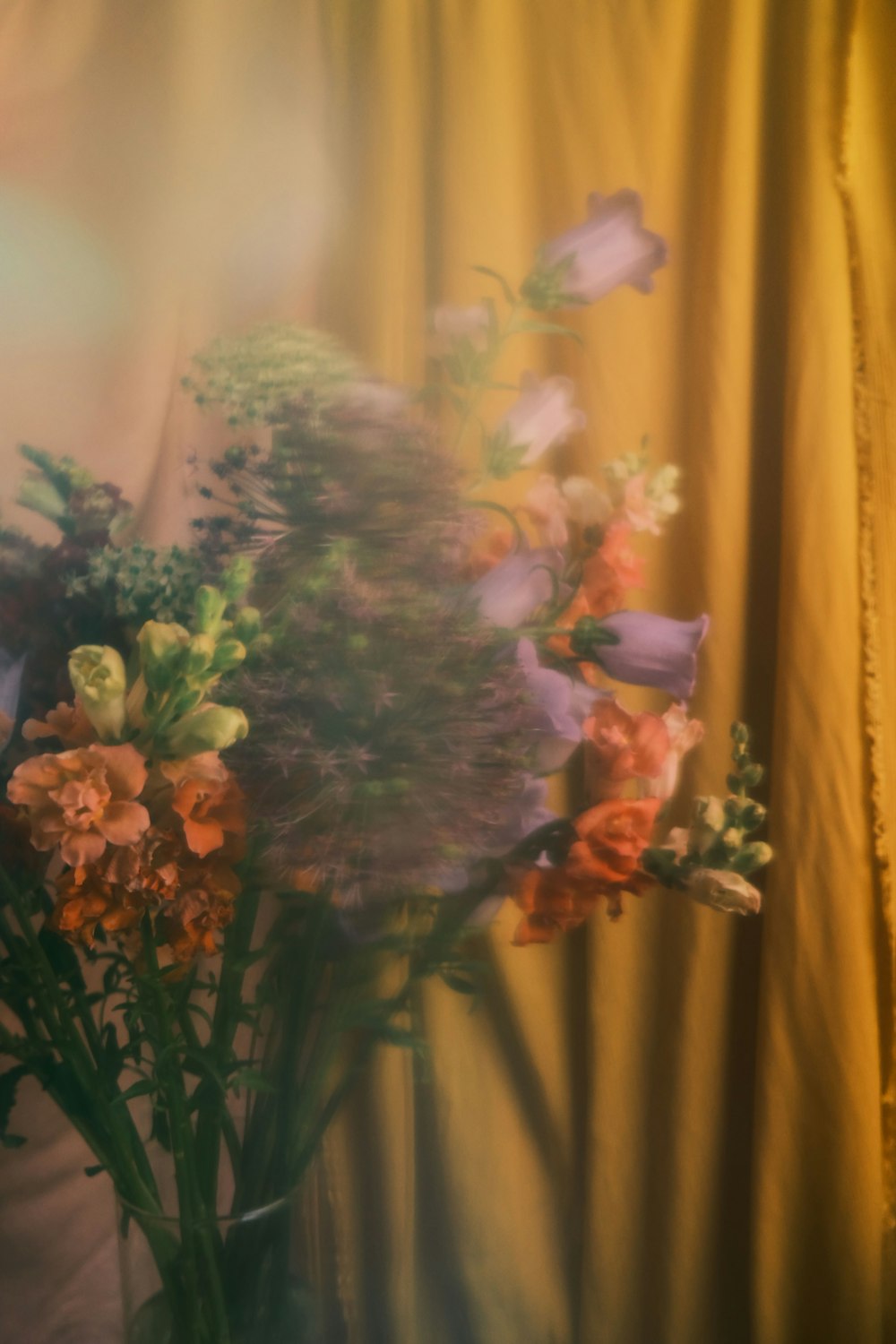 a vase filled with lots of flowers on top of a table