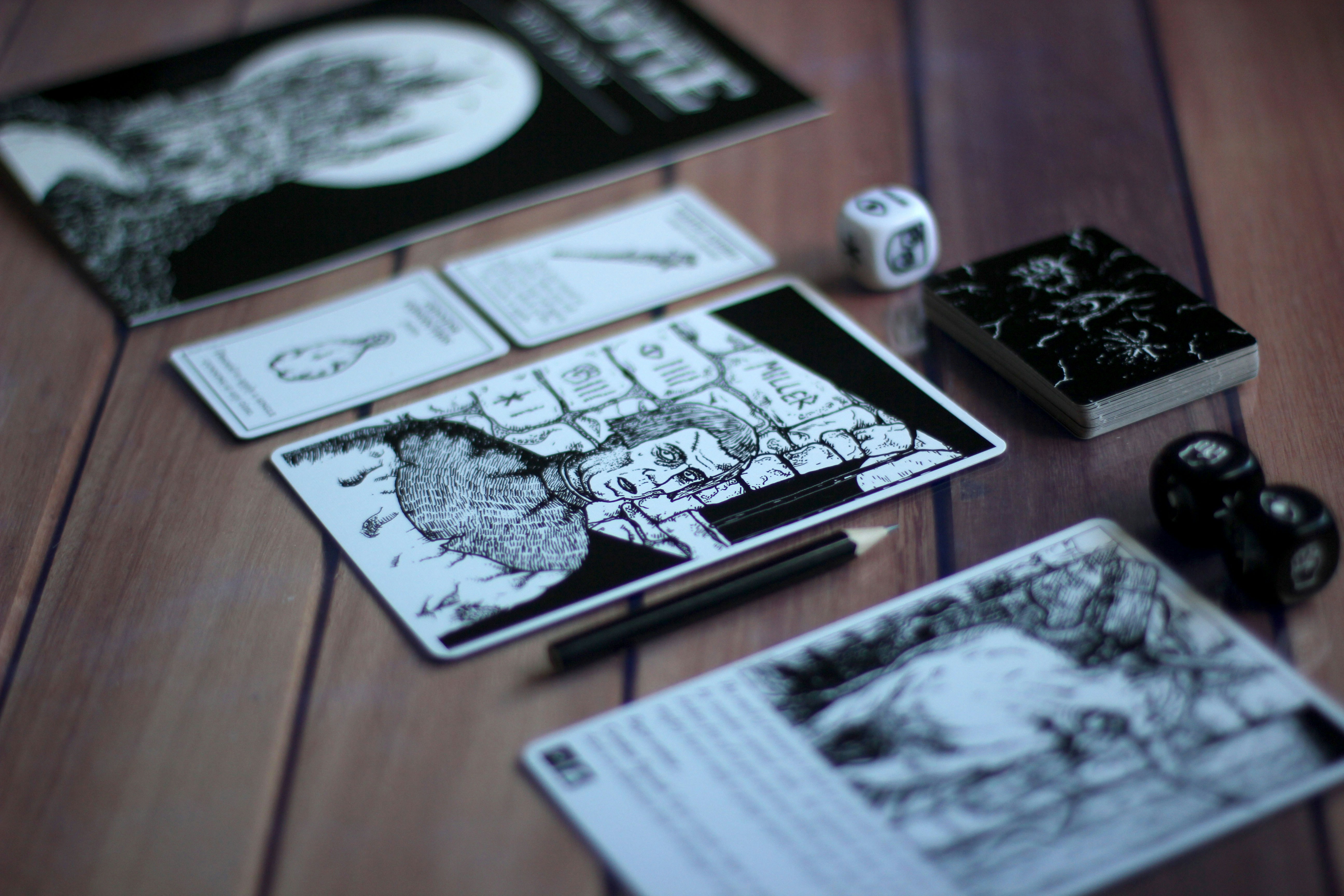 a wooden table topped with notebooks and dice