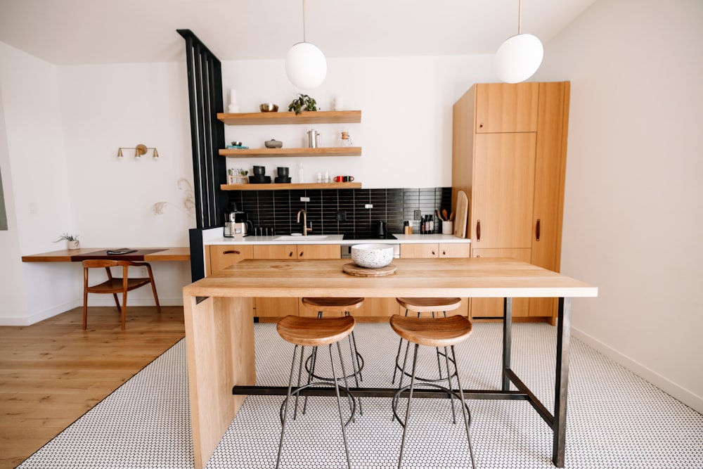 a kitchen with a table and stools in it