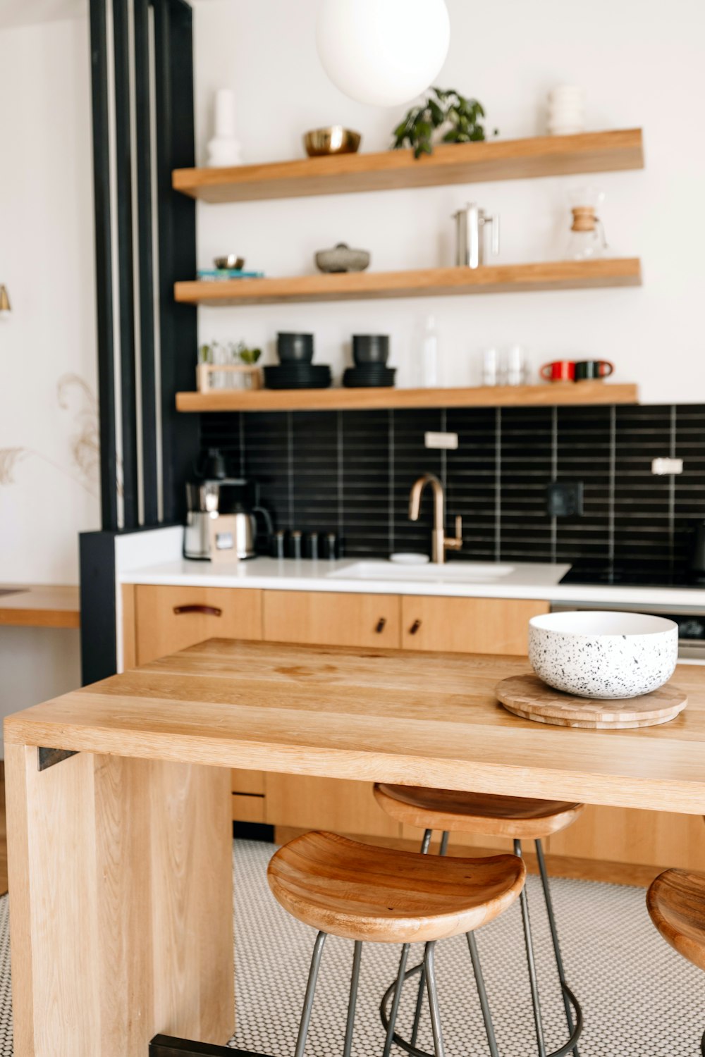 a kitchen with a wooden table and two stools