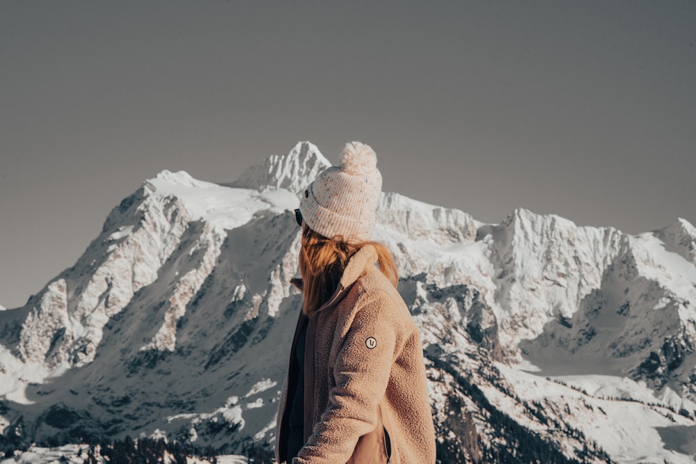 a woman standing on top of a snow covered slope
