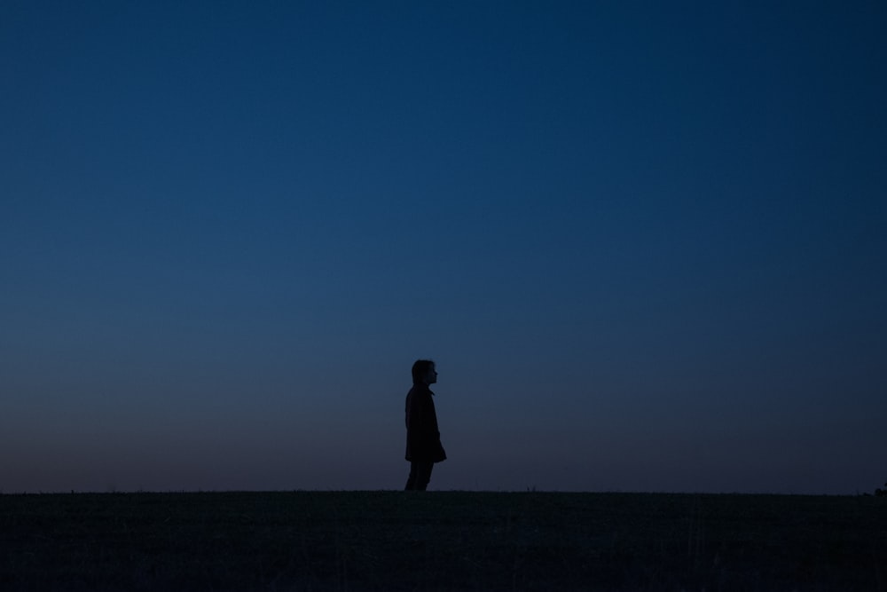 una persona in piedi in un campo di notte