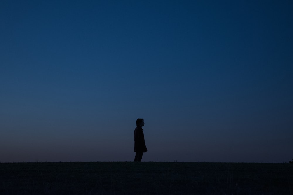a person standing in a field at night