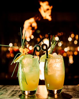 a couple of glasses filled with drinks on top of a table