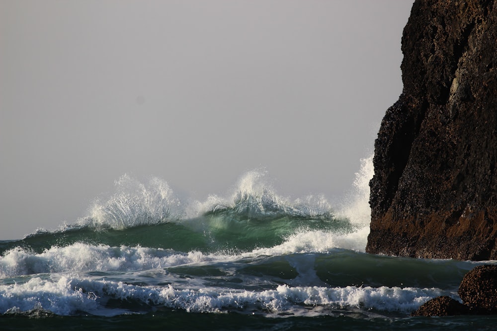 a large body of water next to a rocky cliff