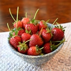 Bright red strawberry and apple powders with fresh fruits on a white ceramic plate