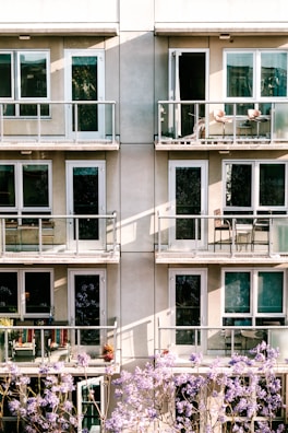A modern apartment balcony decorated with plants and a view of a vibrant urban park.
