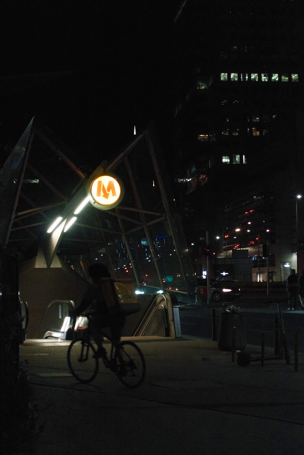 a man riding a bike down a street at night