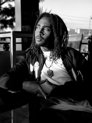 Elegant dreadlocks adorned with colorful beads and wraps, captured outdoors in sunlight.