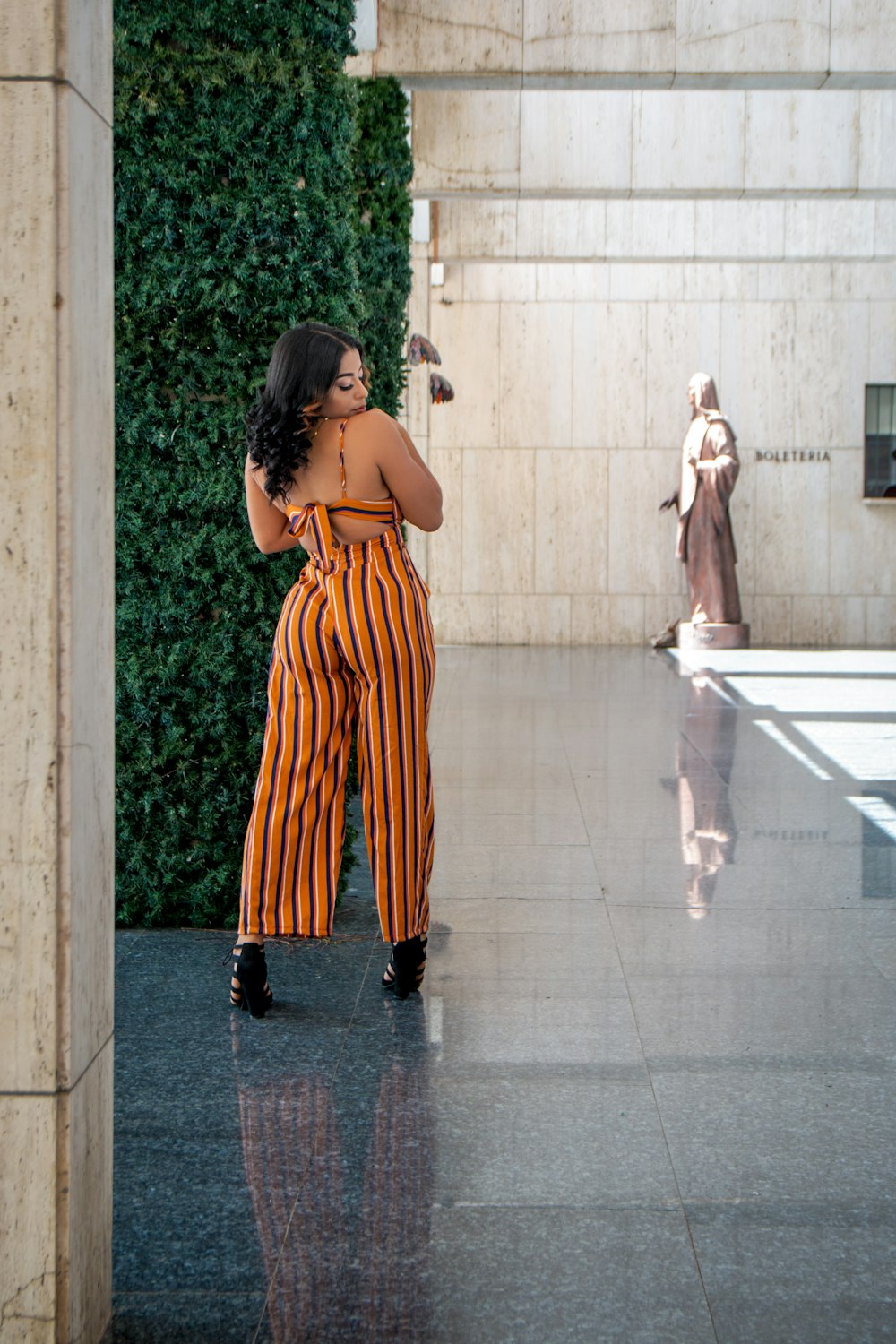 a woman in a striped jumpsuit is taking a selfie