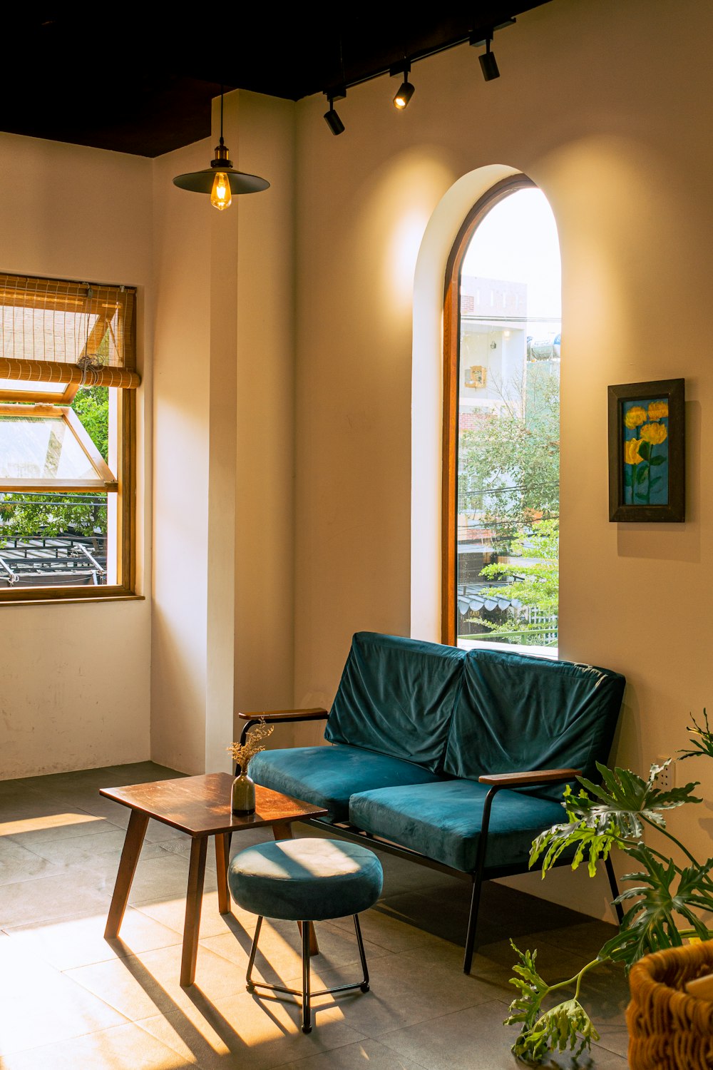 a blue couch sitting in a living room next to a window