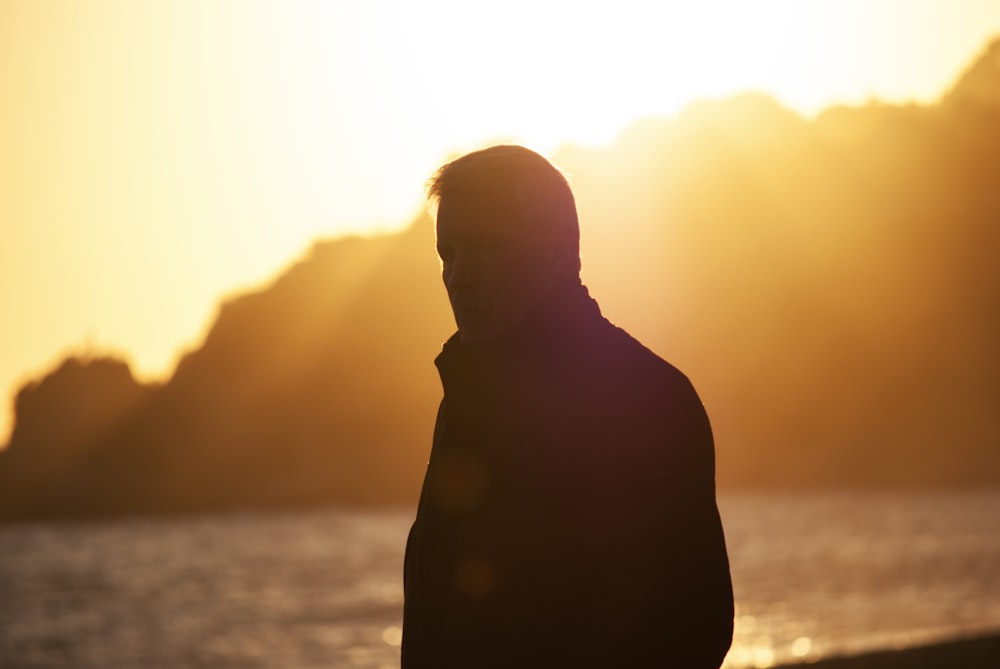 a man standing in front of a body of water