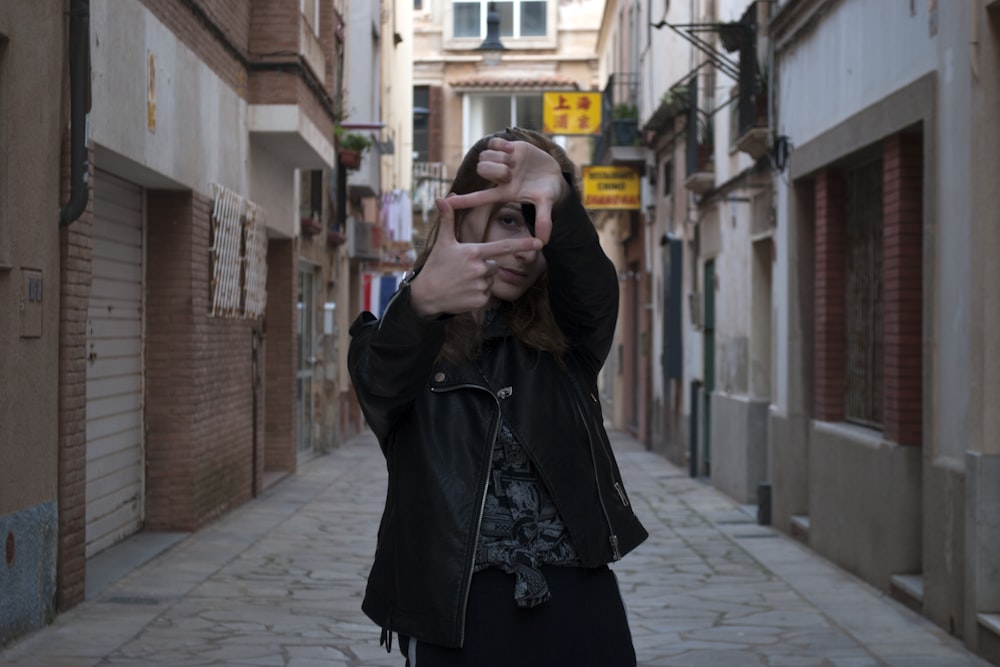 a woman taking a picture of herself in the street