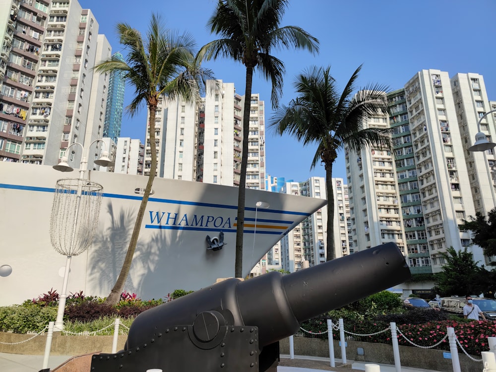 Un gran cañón de metal sentado frente a edificios altos