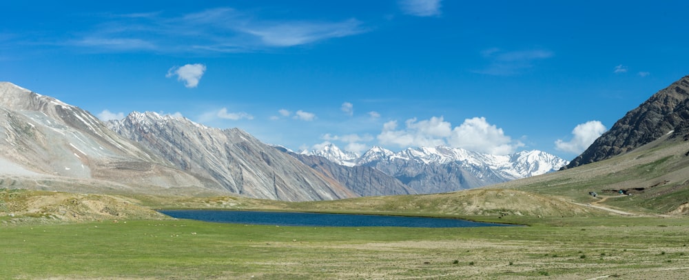 Une chaîne de montagnes avec un lac au premier plan